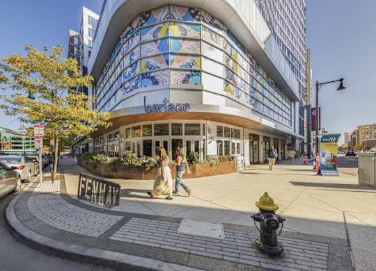 A street view of a building with a fire hydrant in front of it.