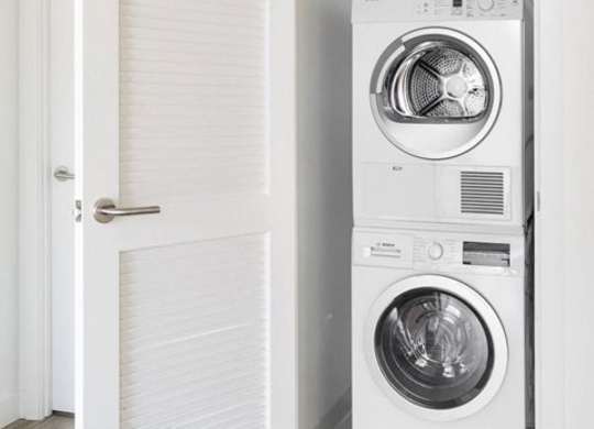 A white washing machine is in a small room.