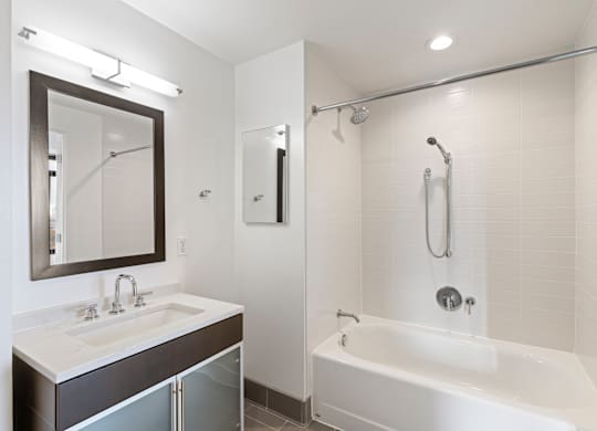 A white bathroom with a white tub and a white sink.
