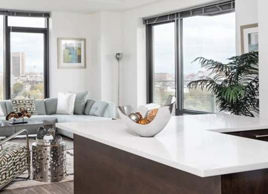 A modern kitchen with a large island and a view of the city.