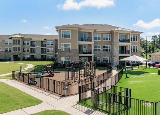 A large apartment complex with a playground in the front.