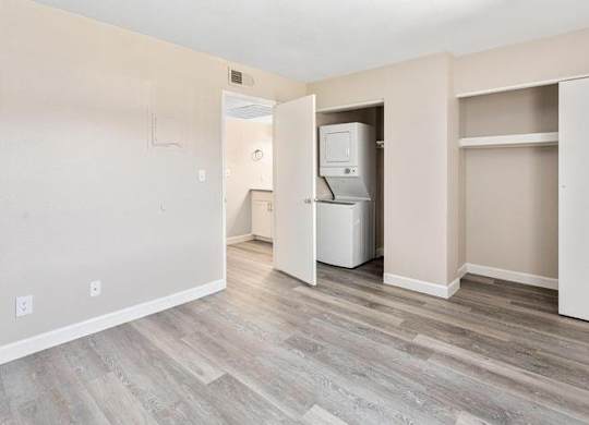 A room with a white fridge and a white door.