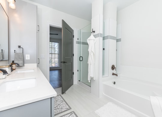a white bathroom with a tub and a sink and a shower
