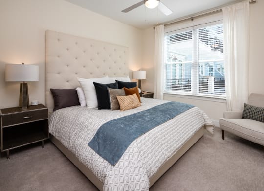 a bedroom with a bed and a chair and a window