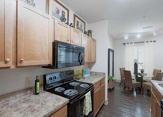 A kitchen with wooden cabinets and a black stove top oven.