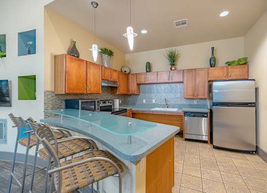 A kitchen with a glass counter top and stainless steel appliances.