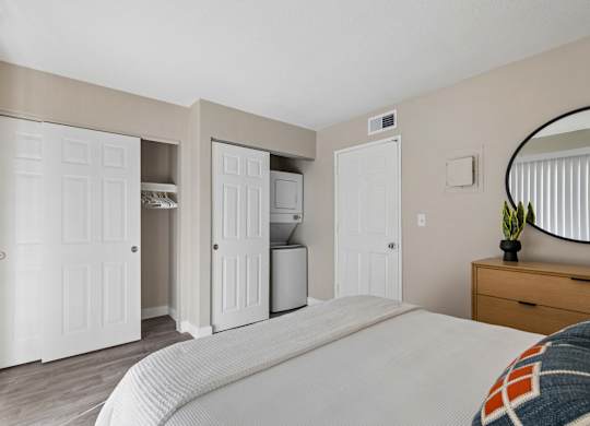 A bedroom with a bed, dresser, and mirror.