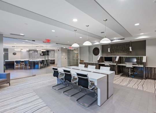 A modern office space with a reception desk and chairs.