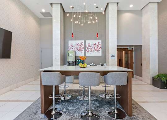 A modern dining area with a long table and grey chairs.