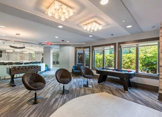 A room with a pool table and a foosball table.