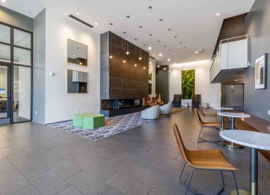 a lobby with tables and chairs and a fireplace