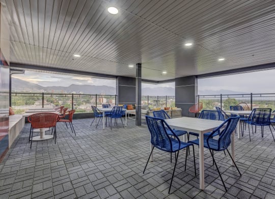 a cafeteria with tables and chairs and a view of mountains