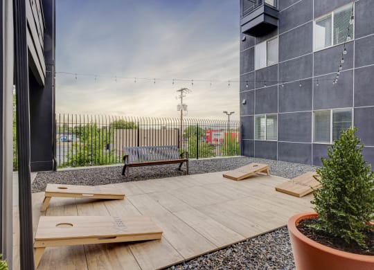 a patio with benches and a tree in front of a building