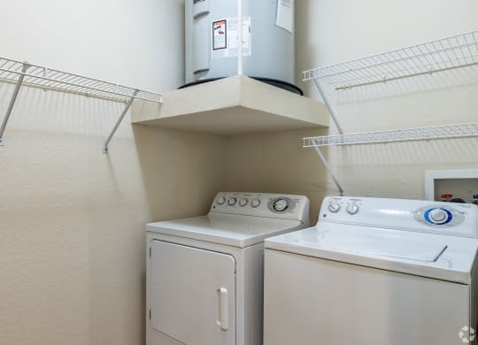 a washer and dryer in a room with a shelf above it and a