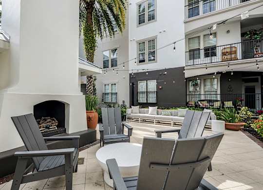 A patio with chairs and a fireplace.