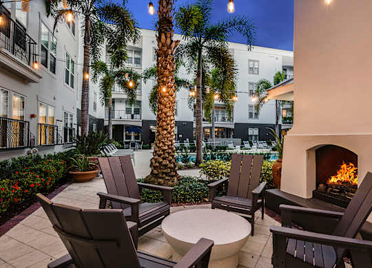 A patio with chairs and a fireplace.