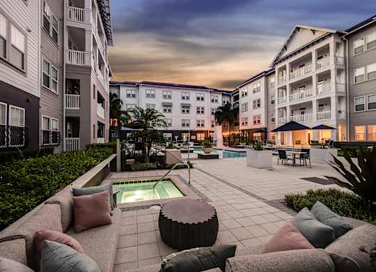 A modern outdoor seating area with a pool surrounded by residential buildings.