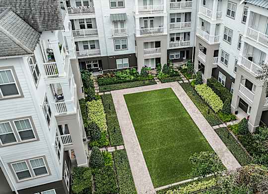 A large grassy area surrounded by buildings.
