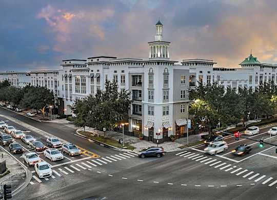 A large white building with a green dome is in the background of a busy intersection.