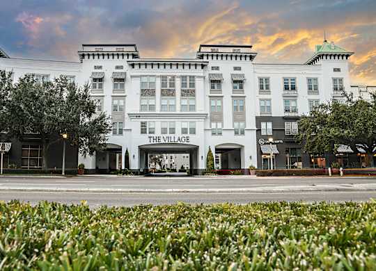 The Village hotel is a large white building with a green roof.