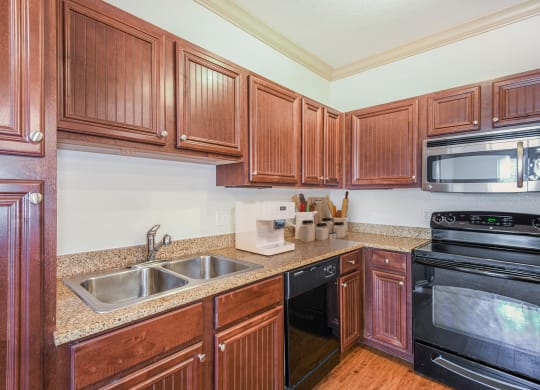 a kitchen with wood cabinets and black appliances