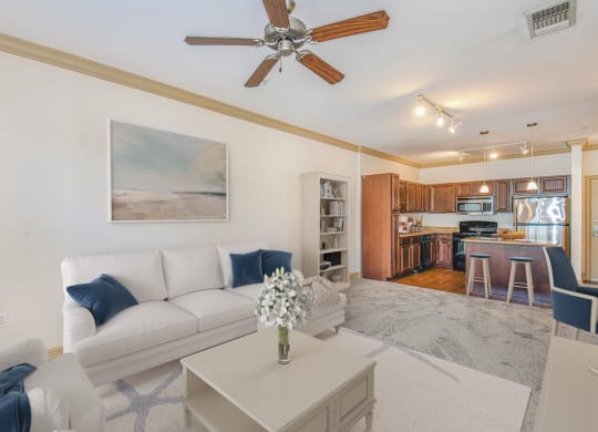 a living room with a white couch and a ceiling fan