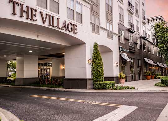 The front of a building called The Village with a white facade.