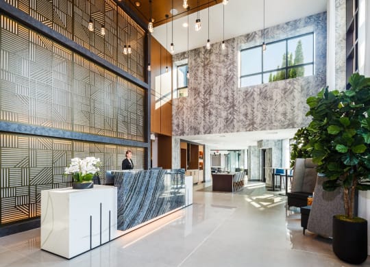 a lobby with a reception desk and a large plant at 100 House Apartments, New Jersey