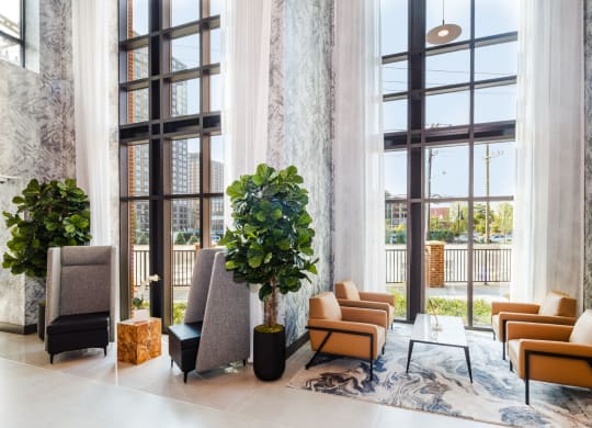 a lobby with couches and chairs and large windows at 100 House Apartments, Jersey City , NJ, 07310