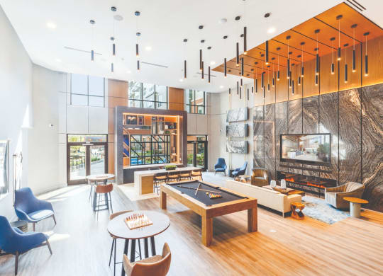 a living room with a fireplace and a pool table at 100 House Apartments, Jersey City