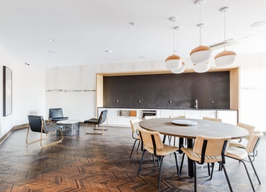 a dining room with a round table and chairs and a kitchen at 100 House Apartments, New Jersey, 07310