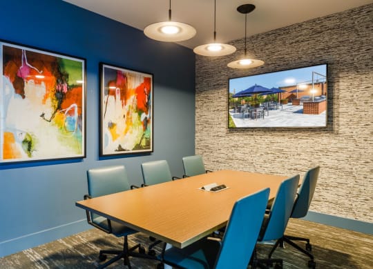 a conference room with a table and chairs and pictures on the wall at 100 House Apartments, New Jersey