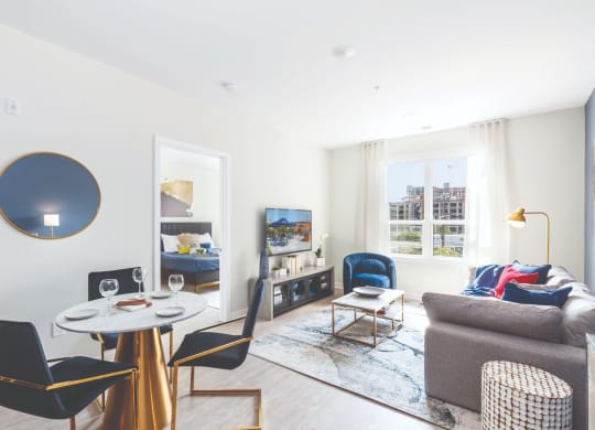 a living room with a couch and a table and chairs at 100 House Apartments, Jersey City , New Jersey