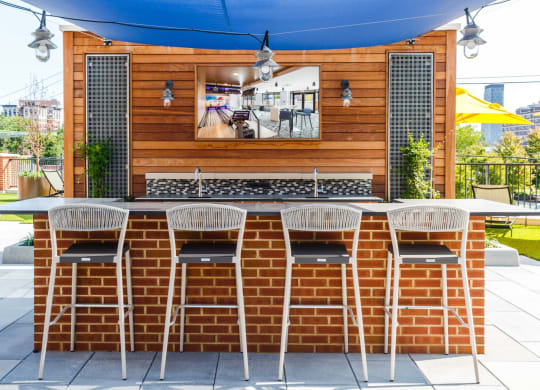 the outdoor bar area of a restaurant with a brick table and chairs at 100 House Apartments, New Jersey
