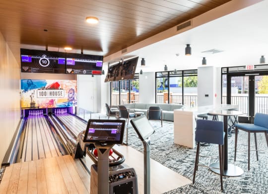a bowling alley in a bowling club with tables and chairs at 100 House Apartments, Jersey City , NJ