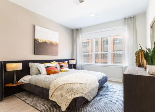 a bedroom with a bed and a large window at 100 House Apartments, New Jersey, 07310