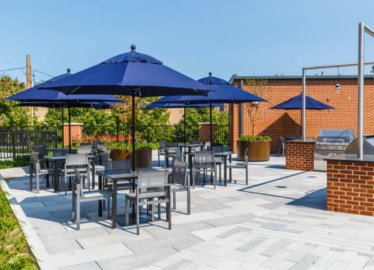 a patio with blue umbrellas and tables with chairs