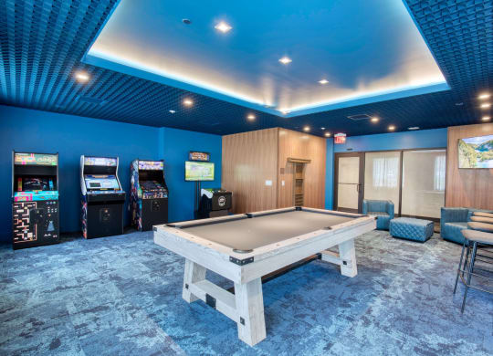 a game room with a pool table and arcade machines