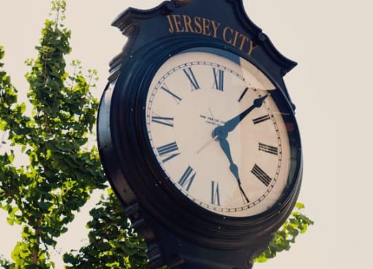 a large clock on top of a pole at One Ten Apartments, Jersey City , New Jersey