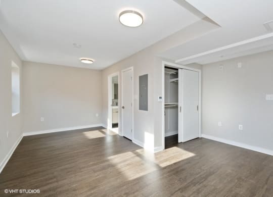 a bedroom with hardwood floors and white walls at Carver and Slowe Apartments, Washington, DC