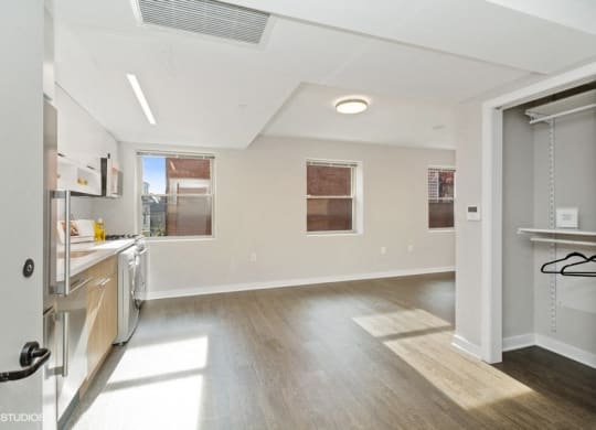 a kitchen and living room with white walls and wood floors at Carver and Slowe Apartments, Washington, DC