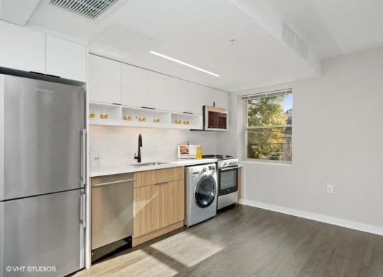 a kitchen with white cabinets and stainless steel appliances at Carver and Slowe Apartments, Washington Washington, DC