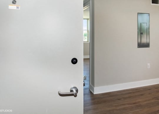 a white door with a silver handle and a hallway in the background at Carver and Slowe Apartments, Washington Washington, DC