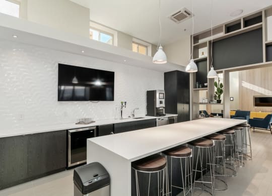 a kitchen with a long white counter and a long row of stools in front of it at Carver and Slowe Apartments, Washington, DC