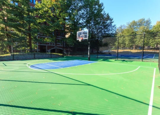 a tennis court with a basketball hoop on it at The Saratoga Apartments, Washington, 20008
