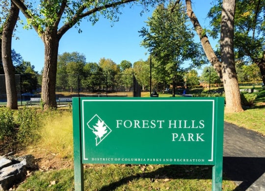 a sign for forest hills park in front of trees at The Saratoga Apartments, Washington, DC