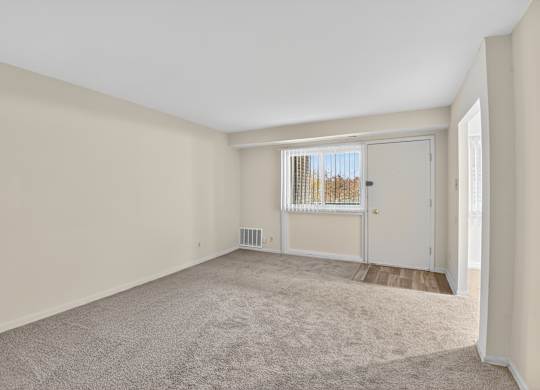 A room with a carpeted floor and a sliding glass door.