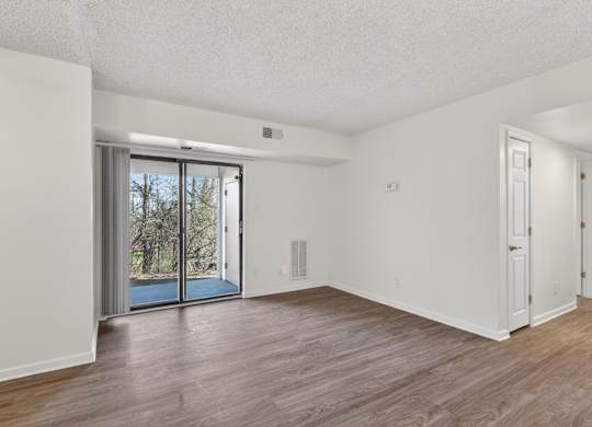 A room with a sliding glass door leading outside.