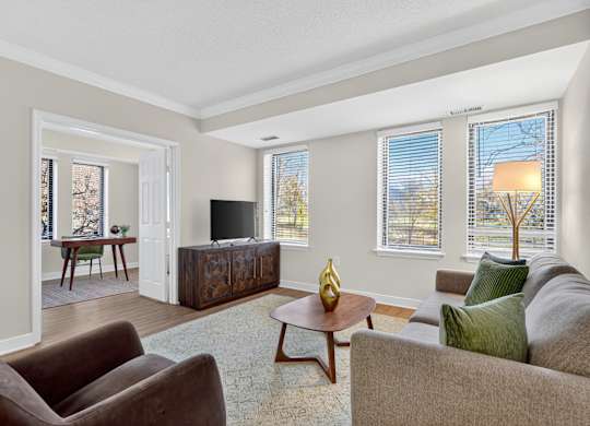 A living room with a brown couch, a wooden coffee table, and a flat screen TV.