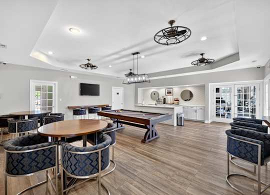 Community room with billiards table, seating with tables and community kitchen with coffee machine